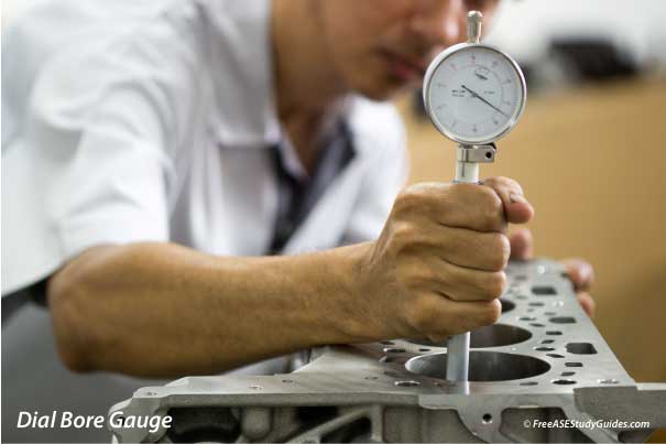 A technician uses a dial bore gauge to take measurements.