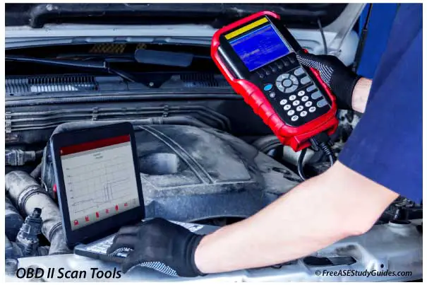 A mechanic using two OBD 2 scan tools.